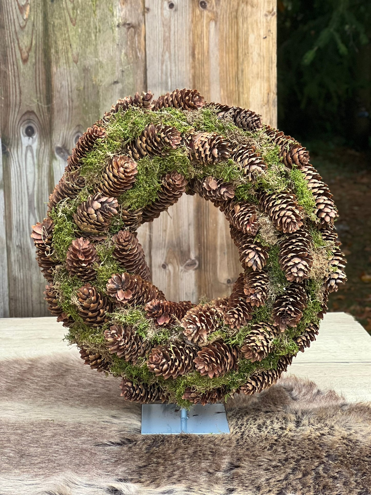 Kranz aus Fichtenzapfen mit Ständer