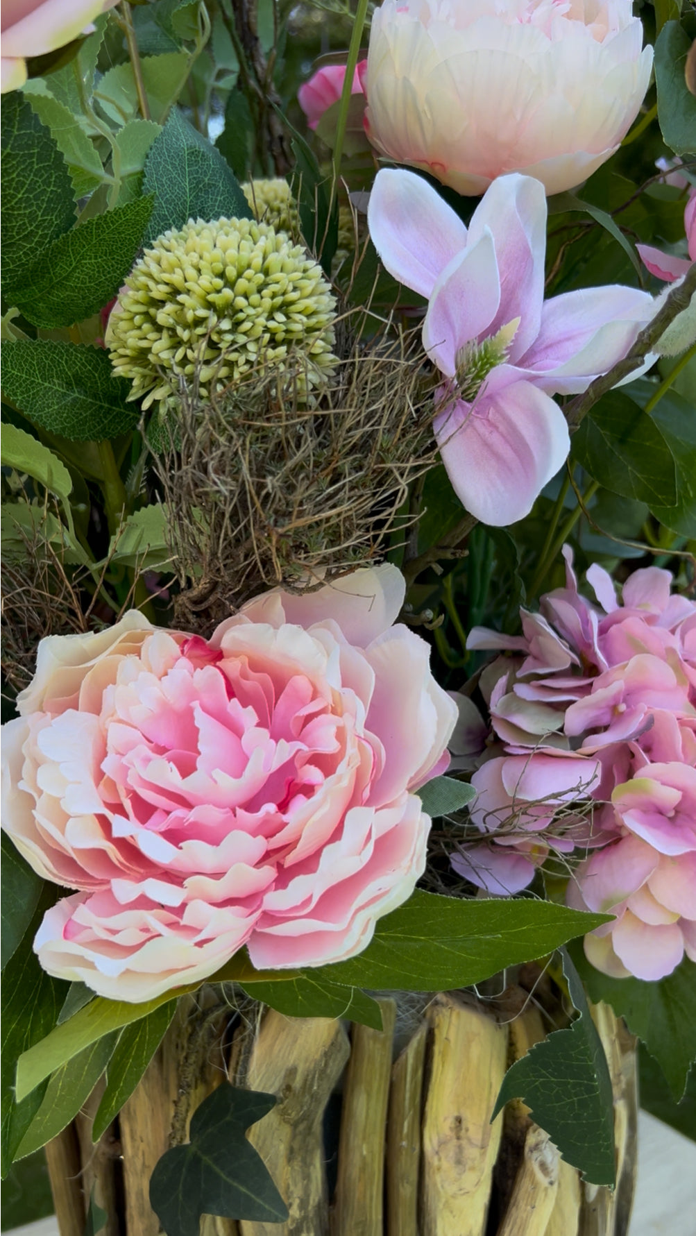 Blumengesteck in einer Holzvase