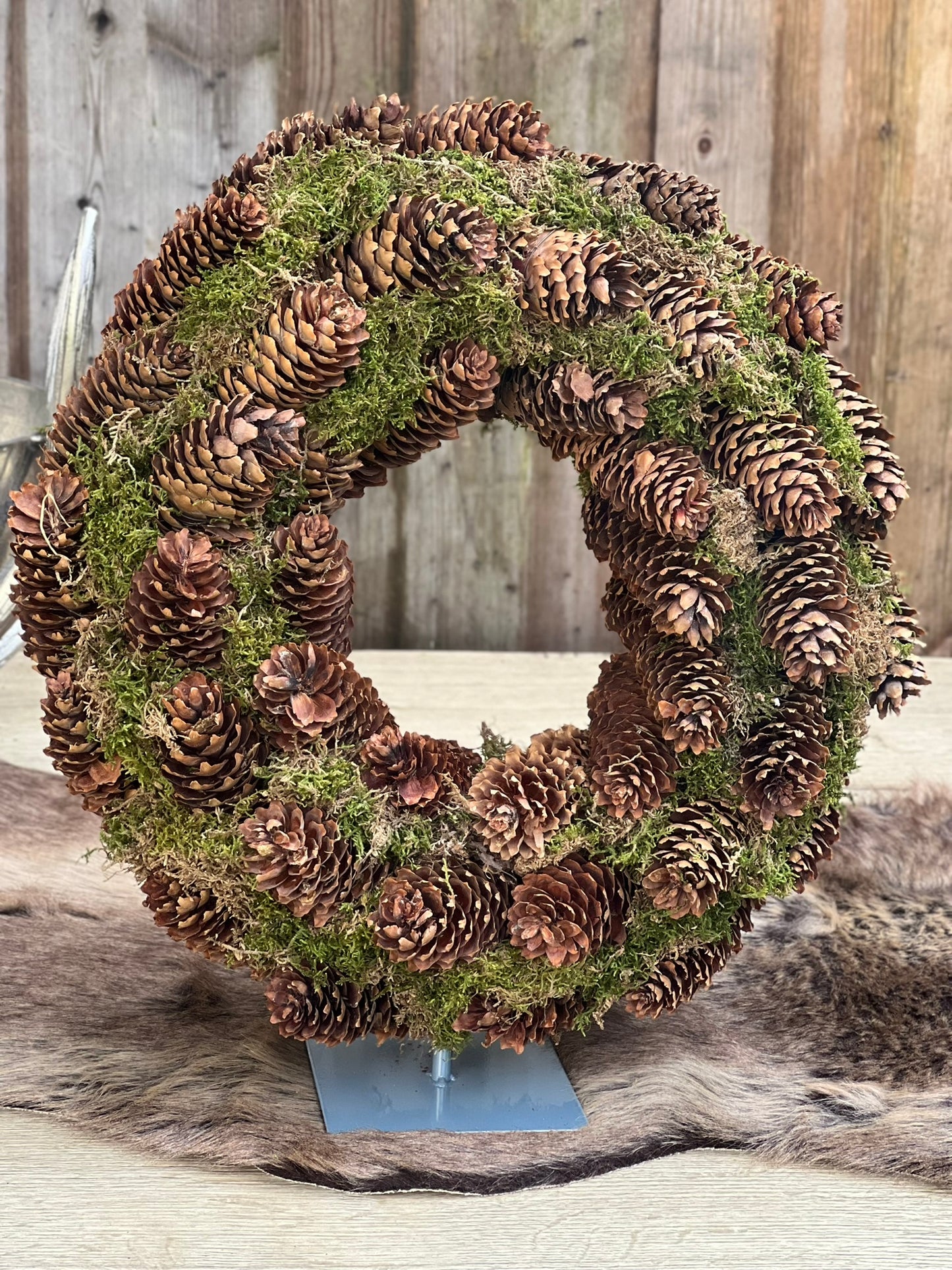Kranz aus Fichtenzapfen mit Ständer