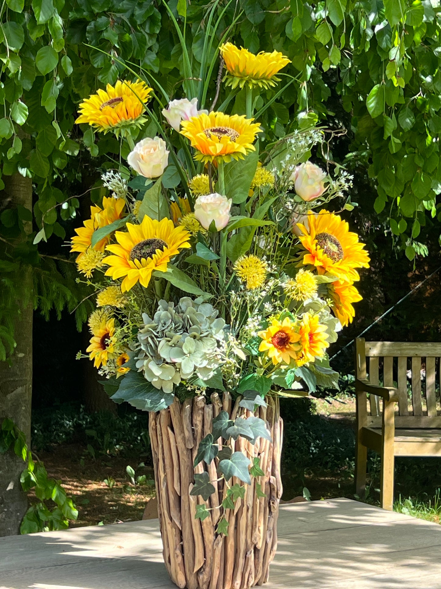 Blumengesteck in einer Holzvase